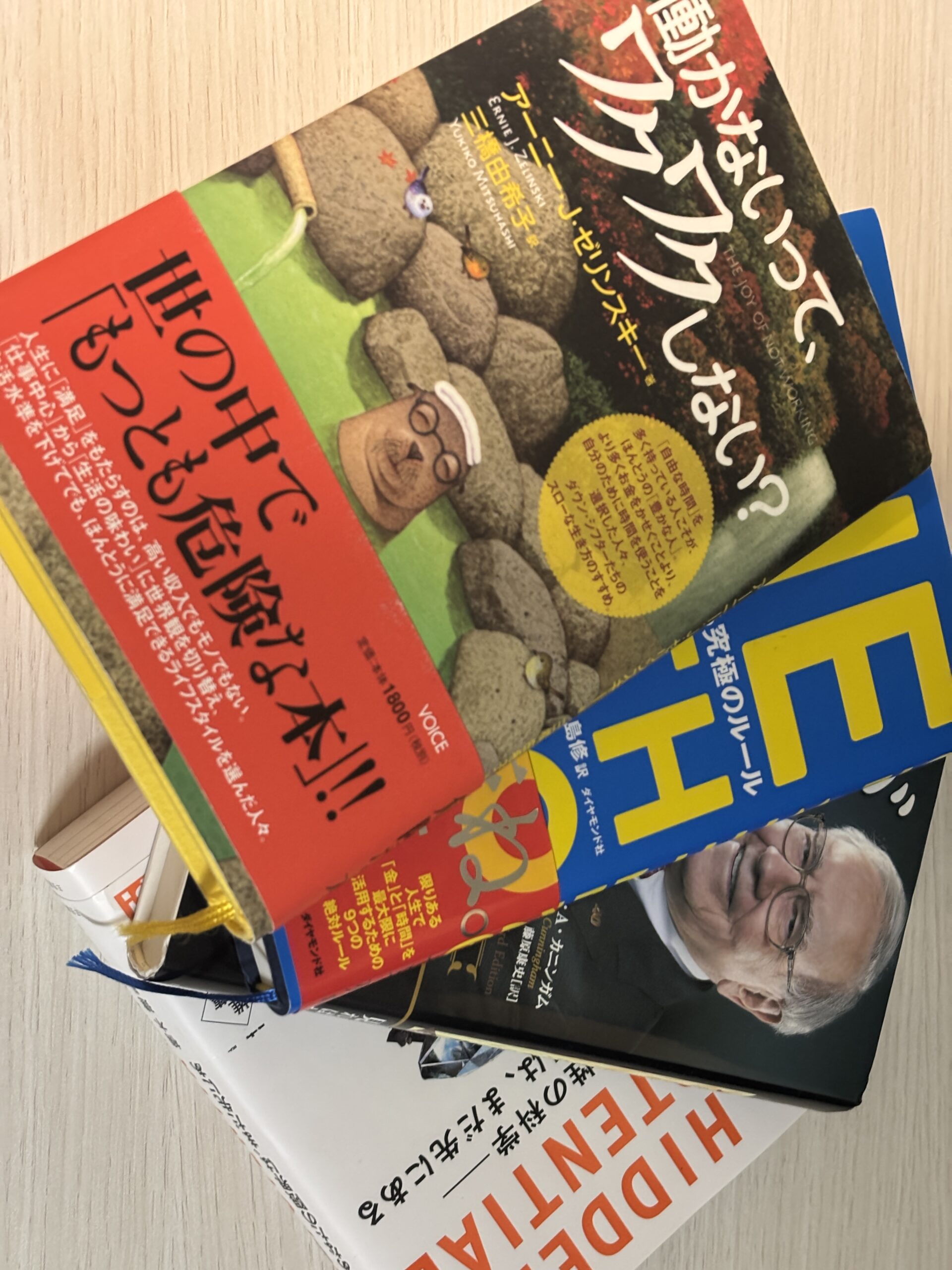 積読中の本を重ねた山（働かないって、ワクワクしない？／DIE WITH ZERO／バフェットからの手紙など）